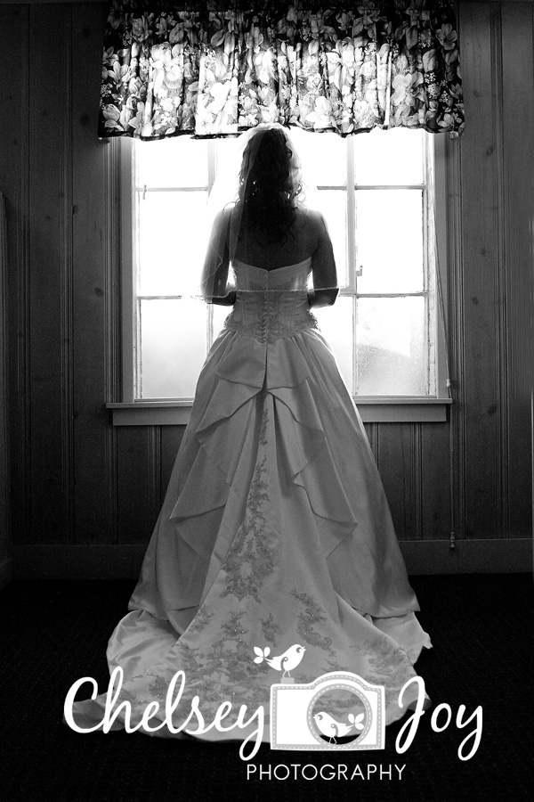 Bride looks out the window at the St. Andrews Golf & Country Club. 