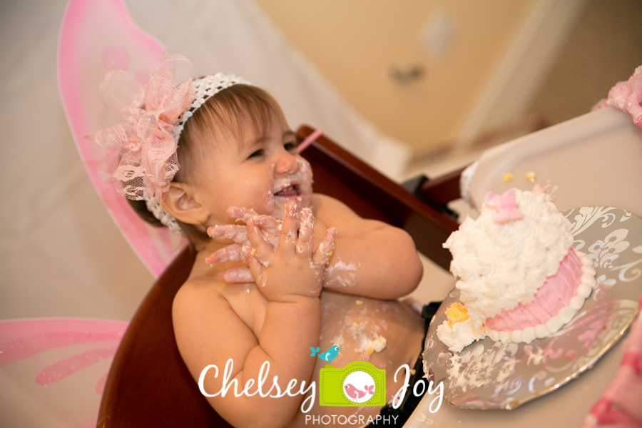Baby J eats cake at her 1st birthday party.