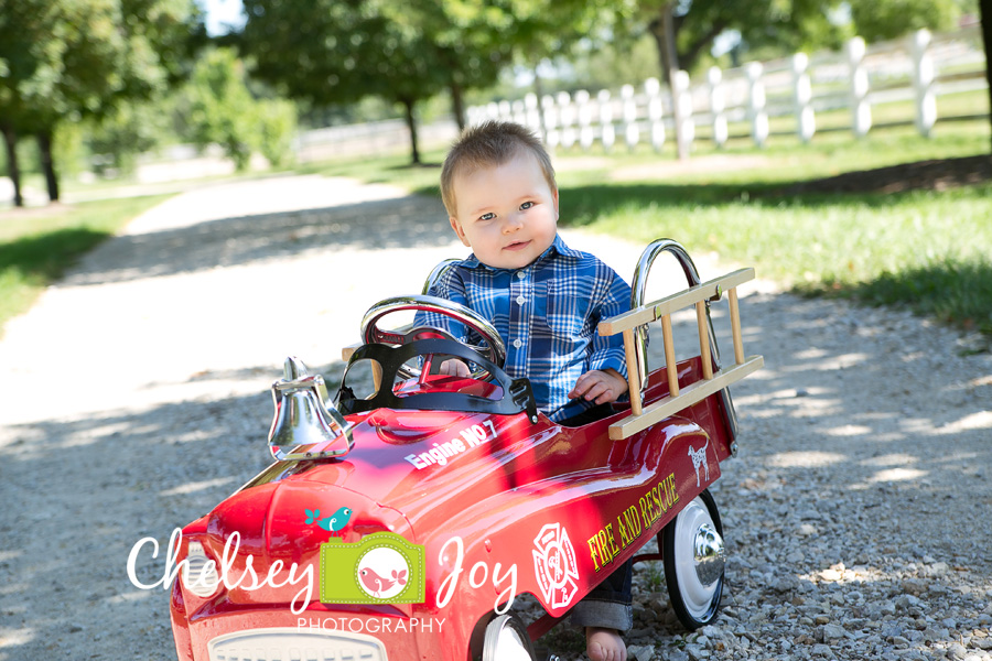 Jackson sits in a toy firetruck.