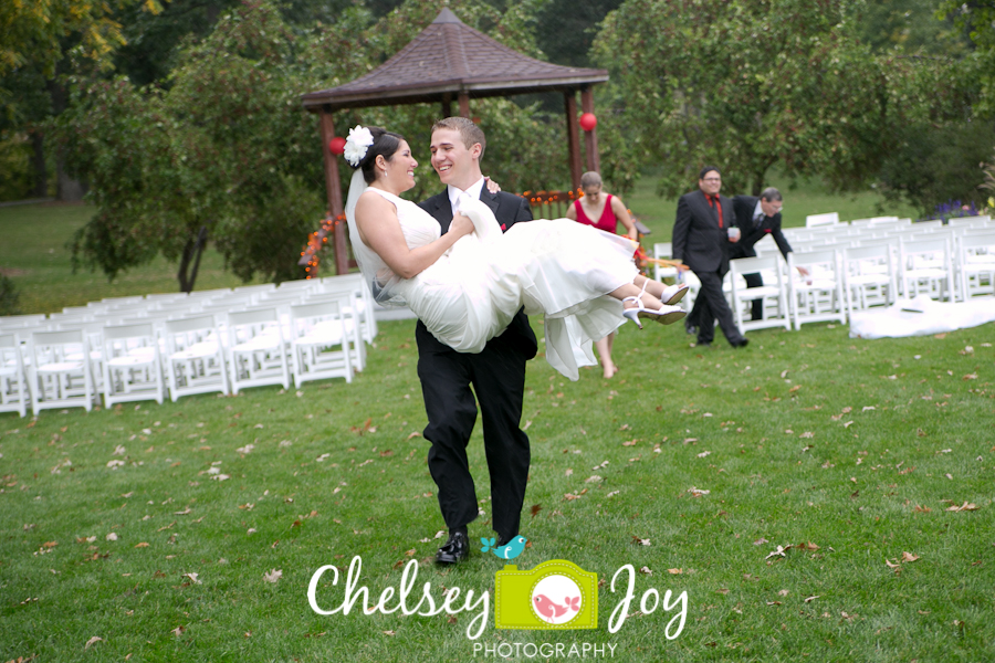 Groom carrying bride at Hopkins Park. 