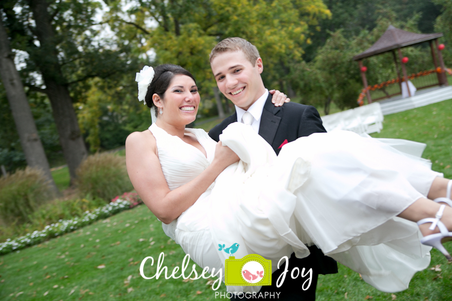 Groom carrying bride at DeKalb outdoor fall wedding.