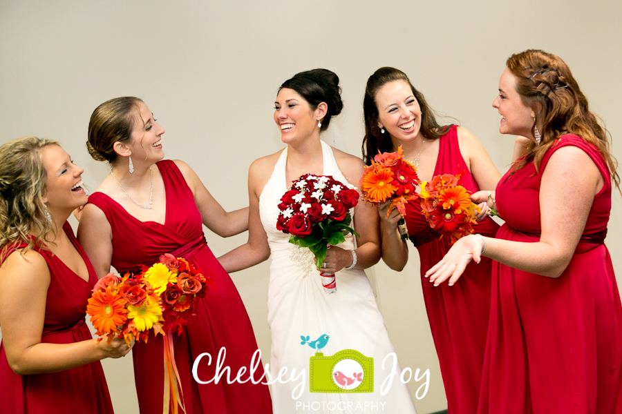 Bride laughing with bridesmaids at wedding in DeKalb. 