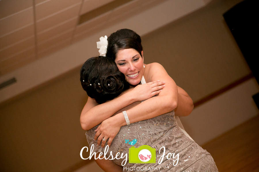 Bride hugging mother at Hopkins Park wedding reception in DeKalb. 