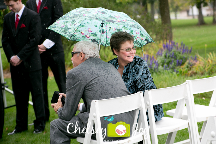 Guest holding umbrella at outdoor wedding in DeKalb. 