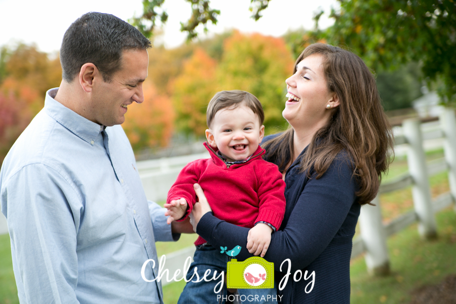 Family laughs while being photographer by a Naperville candid baby photographer.