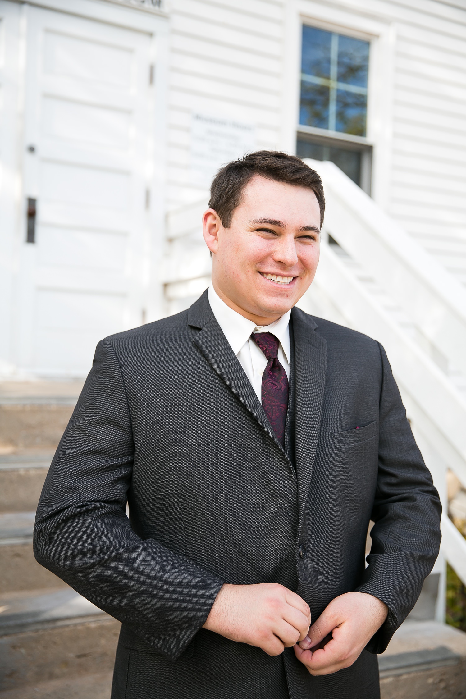 Groom putting on jacket