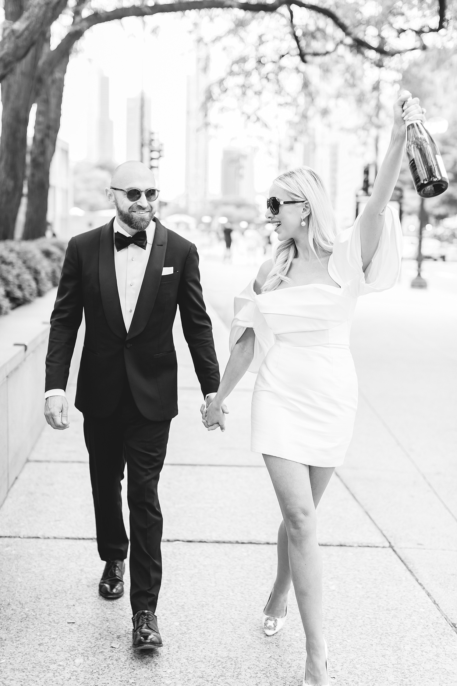 Couple walking with champagne to celebrate their Chicago elopement