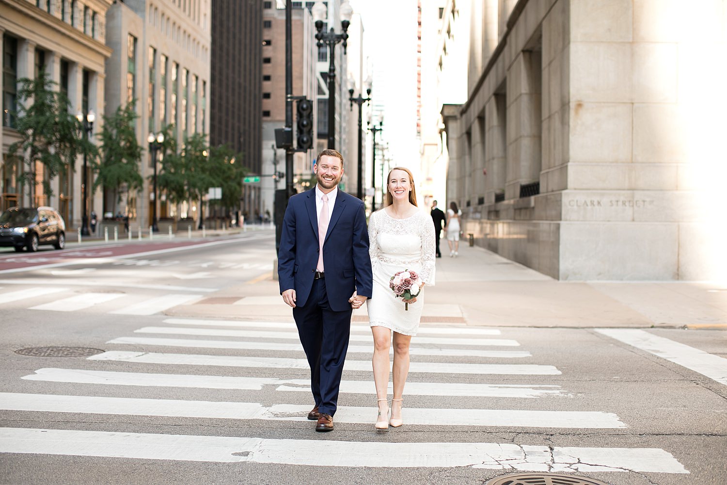 Couple walks down street after their courthouse wedding in Chicago.