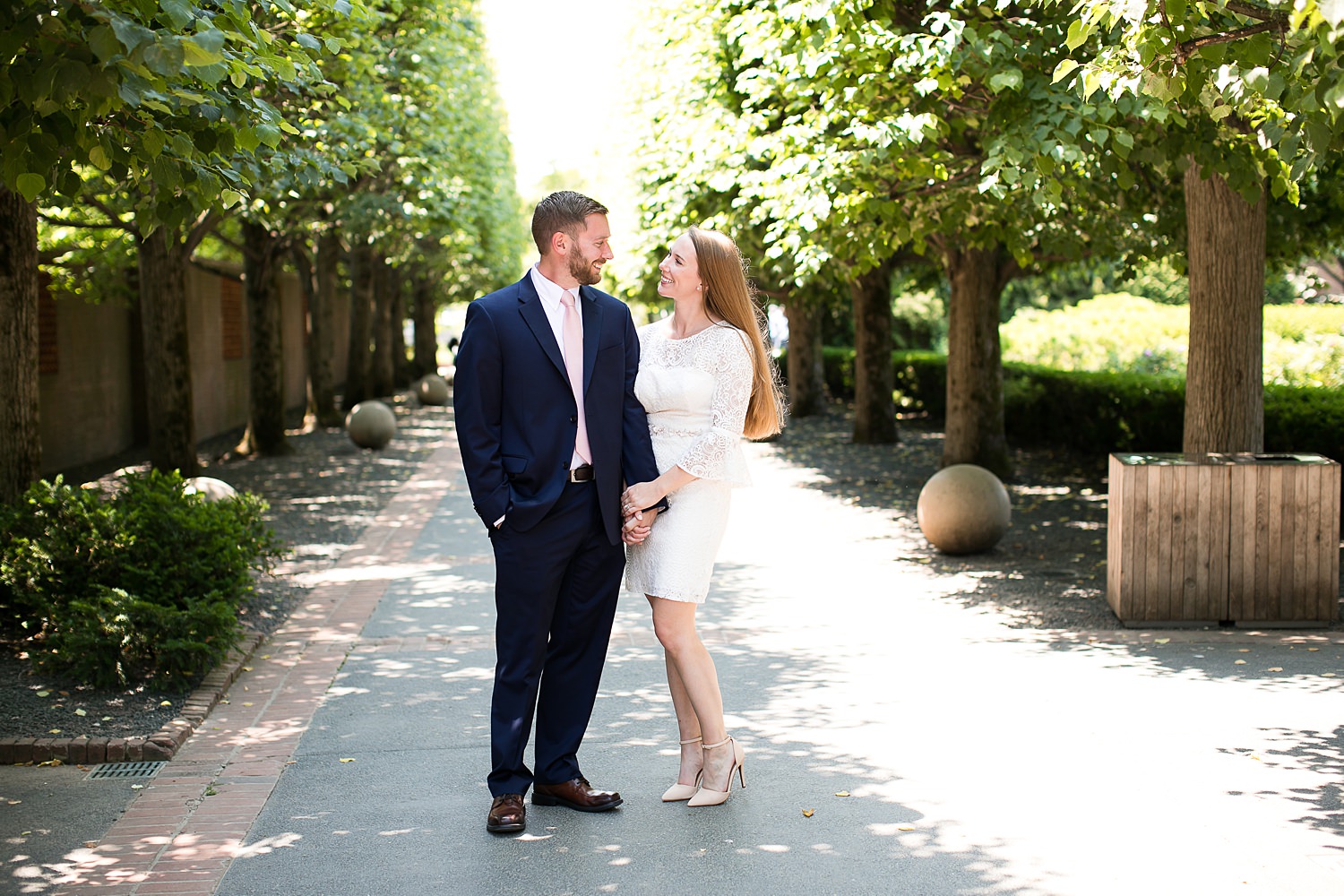 Couple stands by trees at the Chicago Botanic Garden.