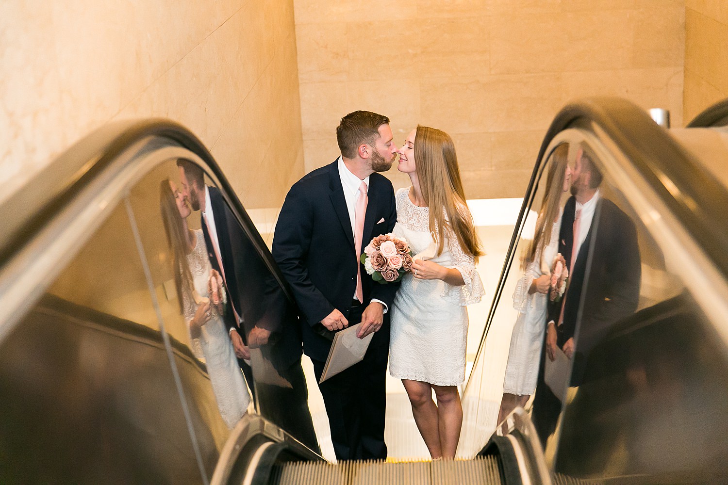 Couple goes up escalator after their elopement at city hall in Chicago.