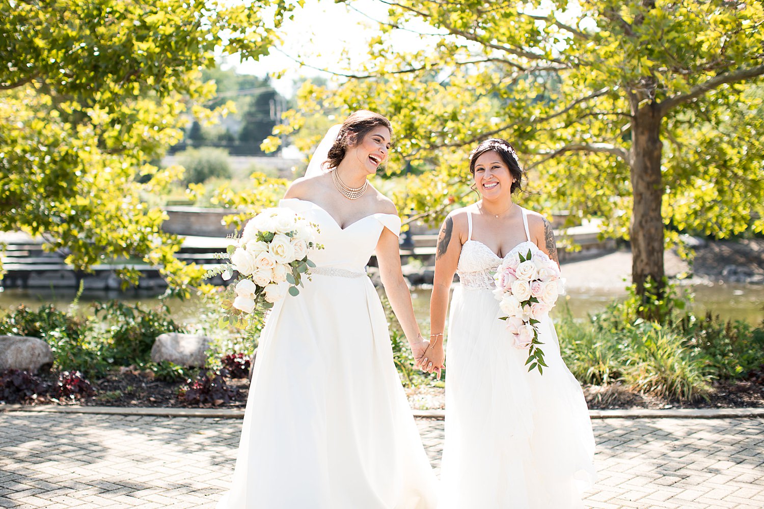 Brides walking in park with bouquets.