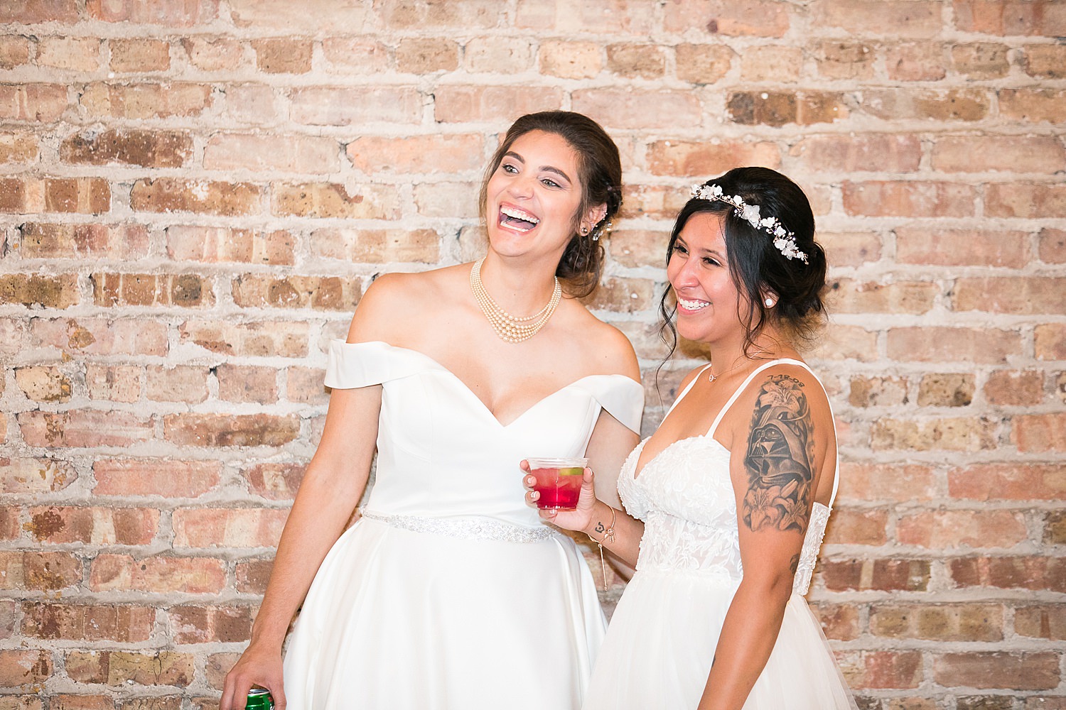 Brides listen to toasts at their wedding reception.