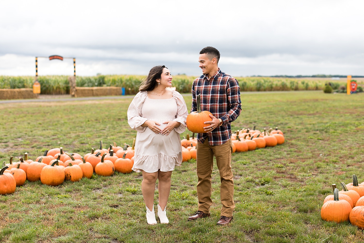 Couple takes maternity photos in pumpkin patch