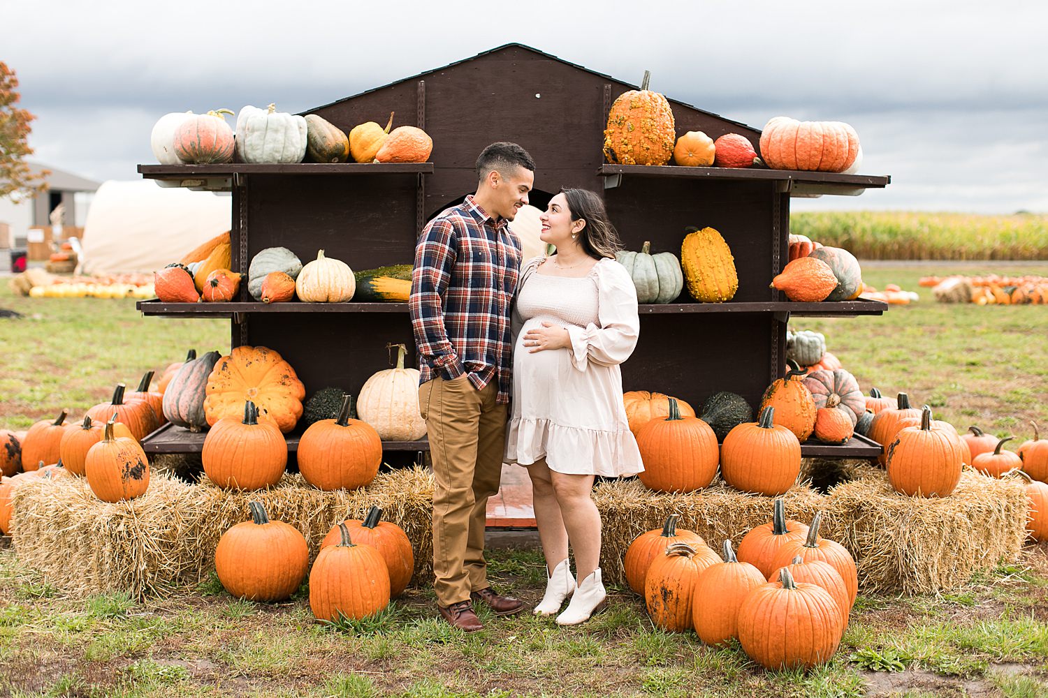 Couple takes maternity photos in pumpkin patch