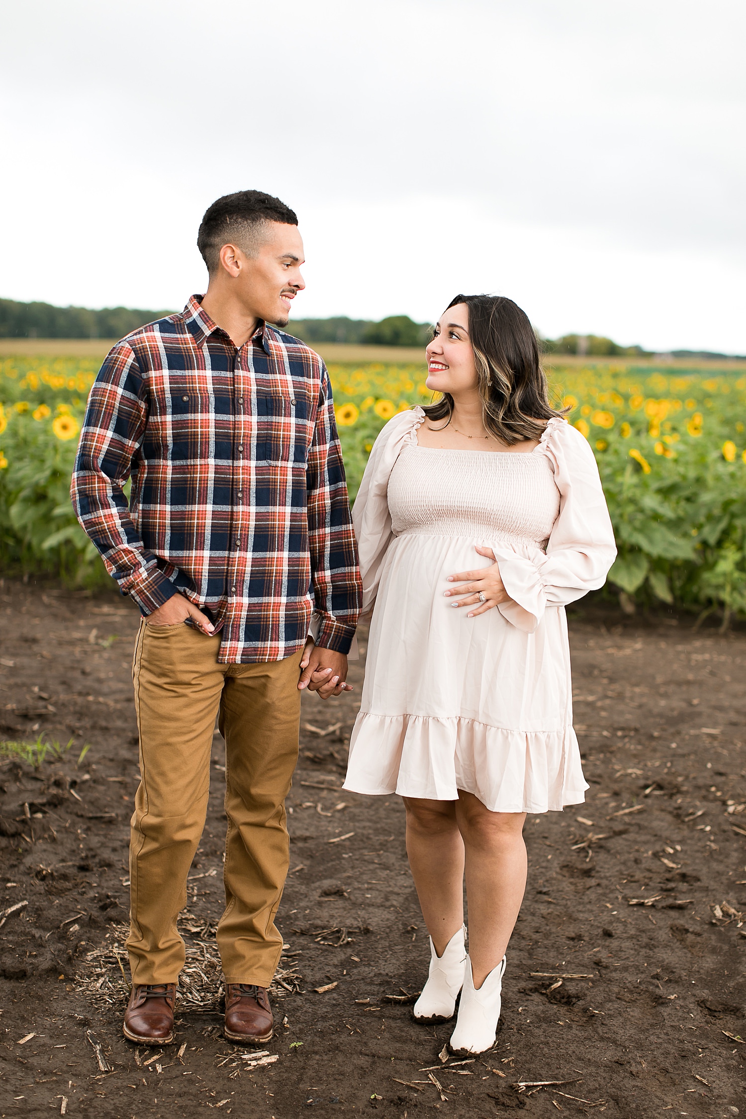 Couple stands in sunflower field