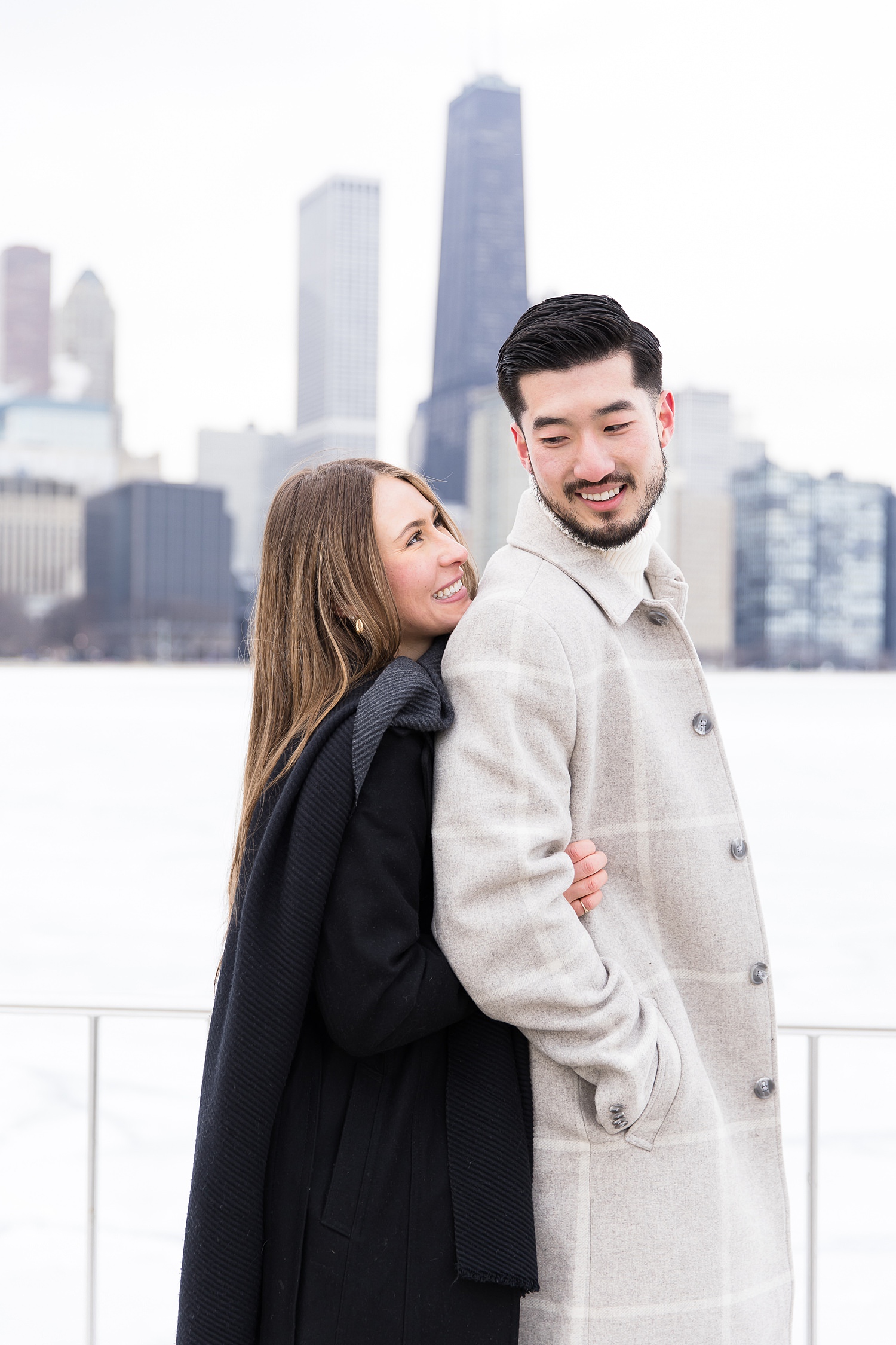 Couple hugs by Chicago skyline.