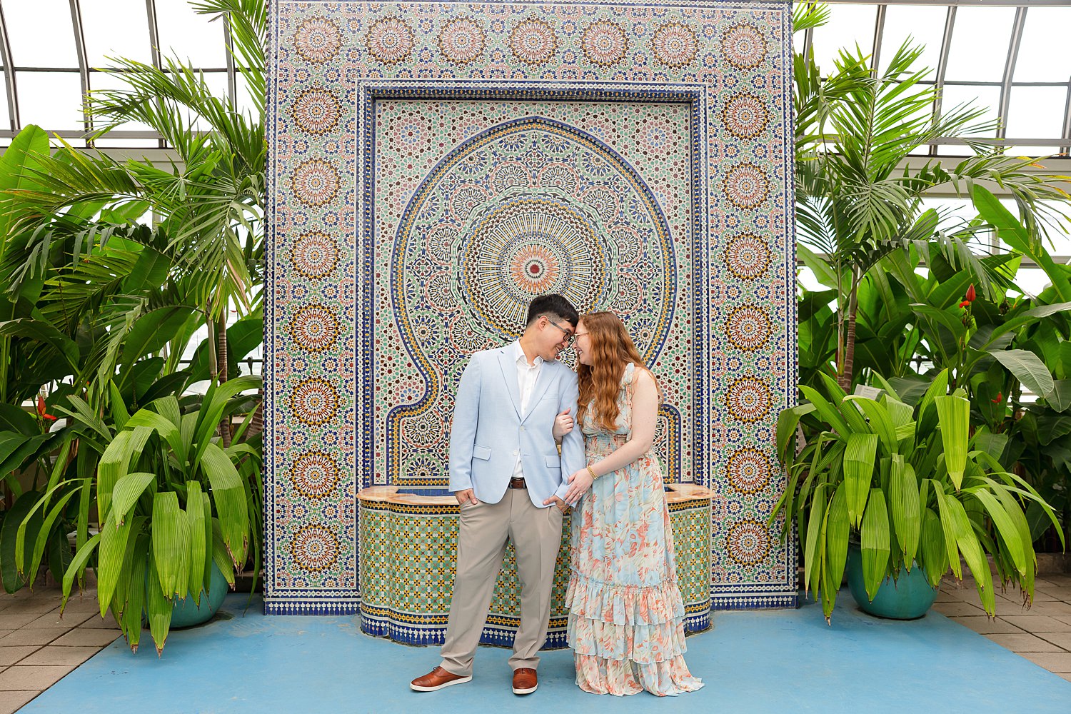 Couple stands in front of mosaic wall at Garfield Park Conservatory