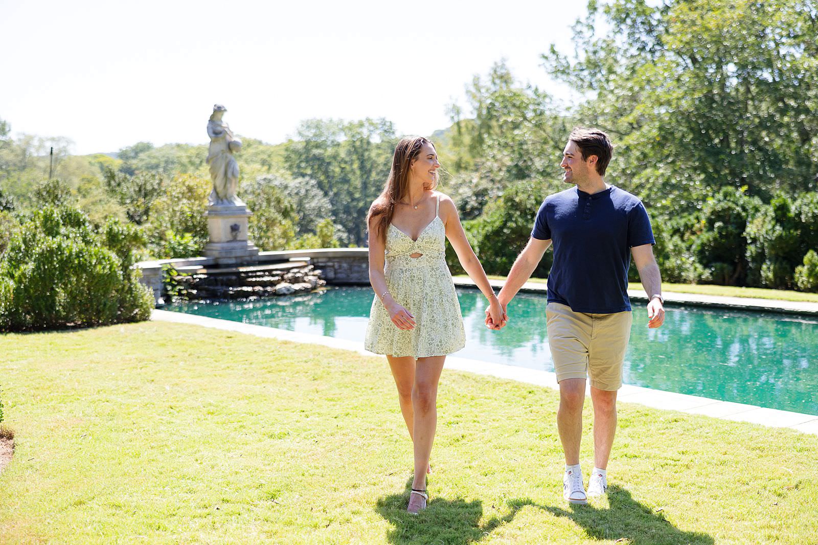 Engaged couple walks by The Reflecting Pool