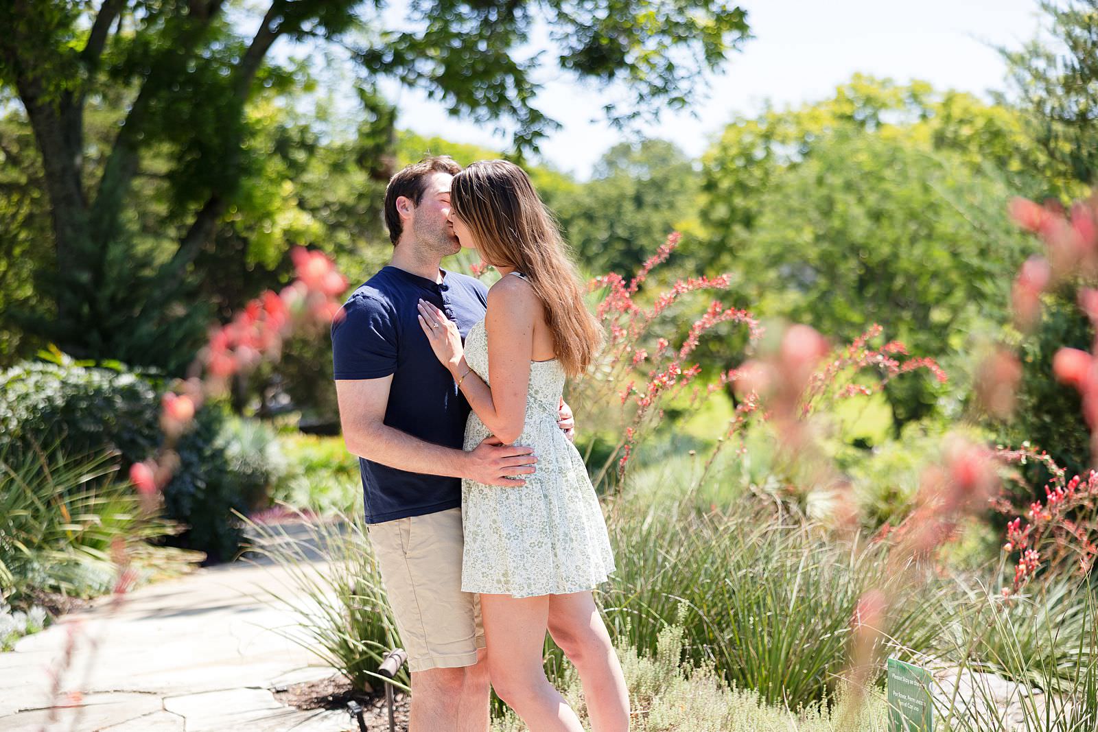 Engaged couple kisses at Sigourney Cheek Literary Garden