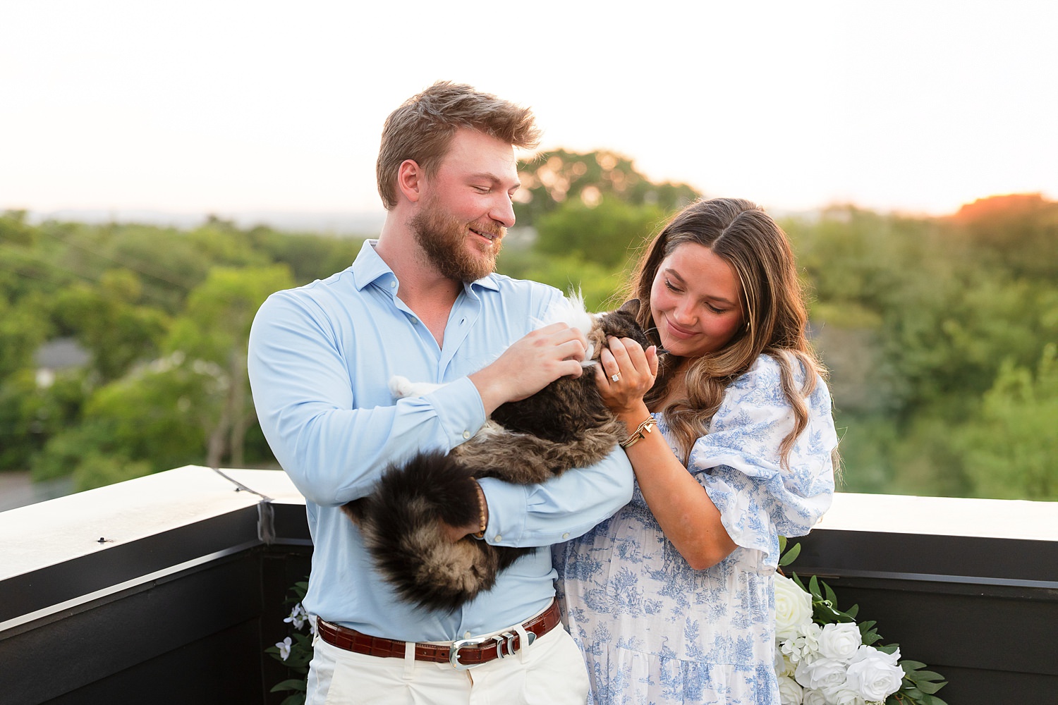 Engaged couple with cat on rooftop in Nashville