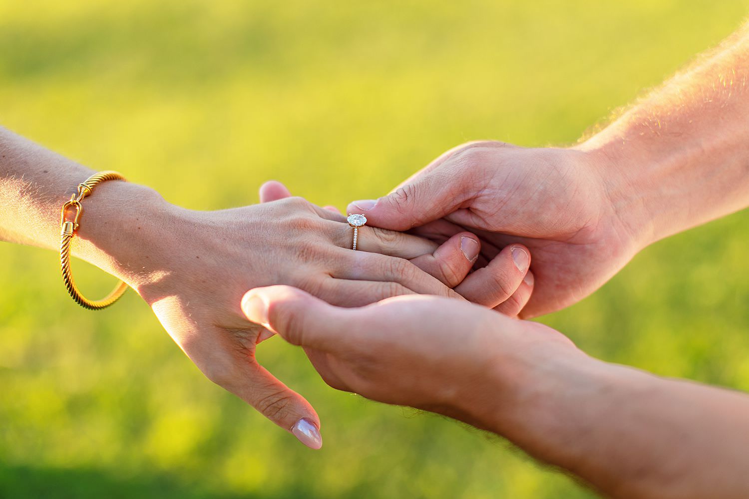 Engaged couple puts ring on finger.