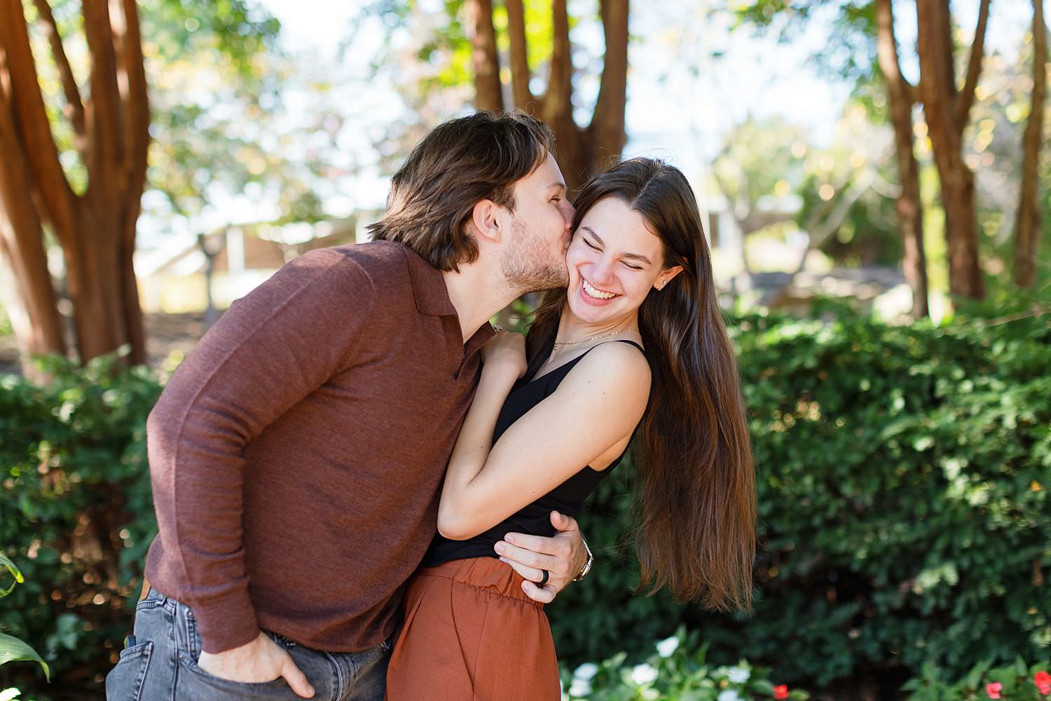 Couple kissing on cheek in Centennial Park in Nashville