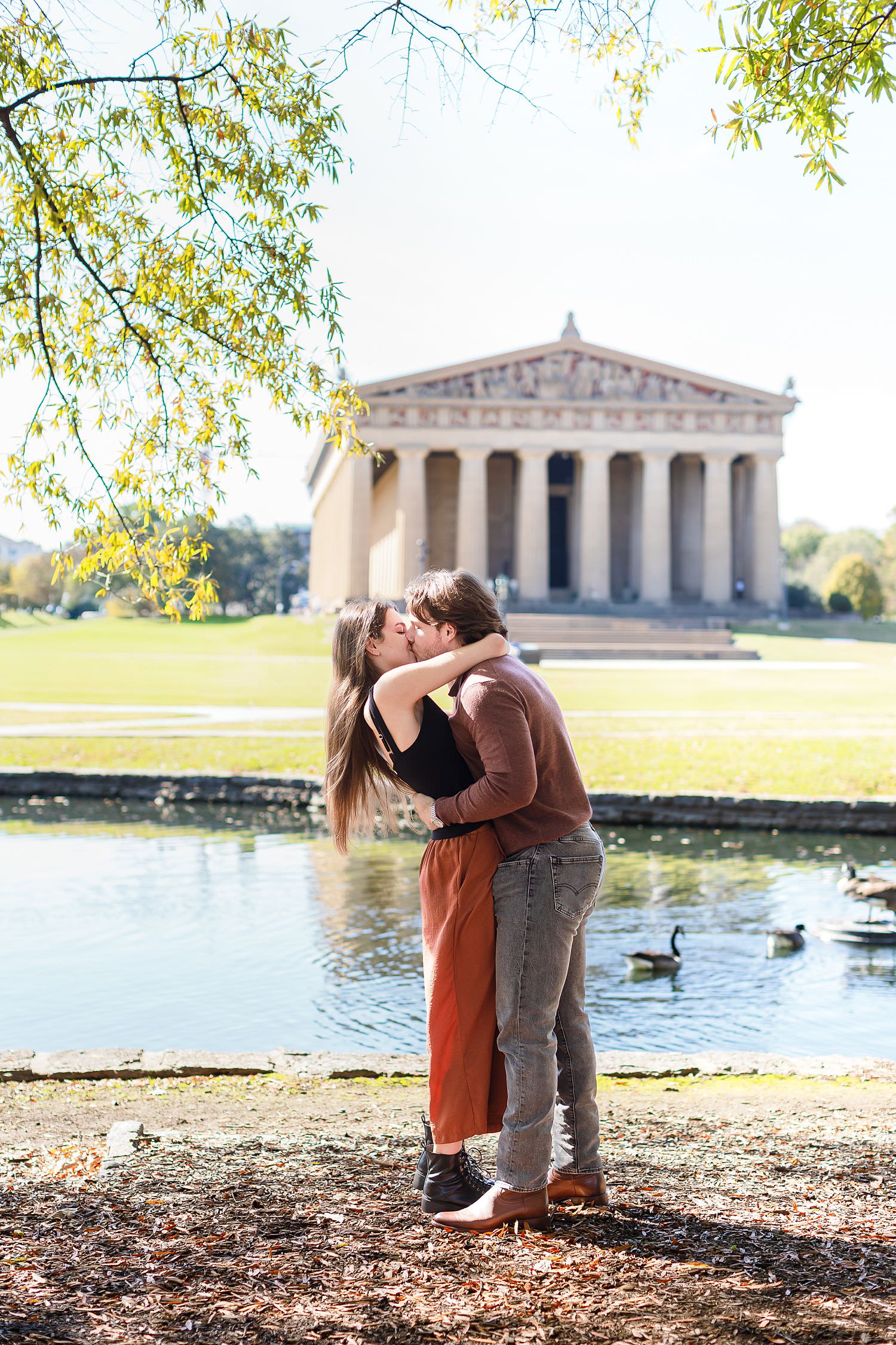 Engaged couple kisses at Centennial Park in Nashville.